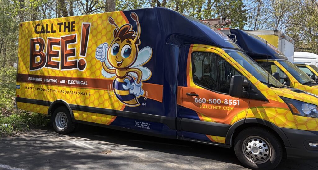Branded service van featuring yellow and navy colors with cartoon bee mascot, displaying plumbing, heating, air, and electrical services contact information.
